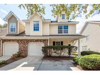 Tan two-story townhome with two-car garage and manicured landscaping at 1151 Saint Pauls Parrish Ln, Johns Island, SC 29455