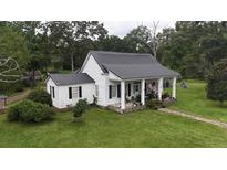 White house with black metal roof and porch at 106 Church St, Reevesville, SC 29471