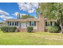 Charming ranch home with brick chimney and well-manicured lawn at 525 Parkdale Drive, Charleston, SC 29414