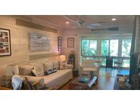 Bright living room with comfy seating, coastal decor, and access to a sunroom at 818 Club Cottage Court, Edisto Beach, SC 29438