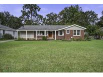 Brick ranch house with covered porch and well-maintained lawn at 121 Matheny Dr, Goose Creek, SC 29445