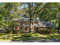 Two story brick home with red shutters, surrounded by lush landscaping at 112 Huckleberry Ln, Summerville, SC 29485