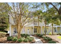 Two-story yellow home with front porch and landscaping at 2934 Sugarberry Ln, Johns Island, SC 29455