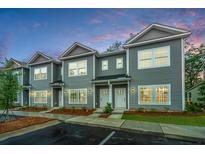 Three gray townhouses with white doors and landscaping at 601 Twin Rivers Dr, Wando, SC 29492