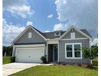 Gray house exterior with white trim, two-car garage and landscaping at 147 Winding Grove Ln, Moncks Corner, SC 29461