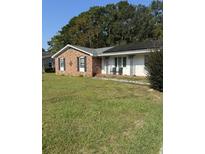 Brick ranch house with a solar panel system and a well-maintained lawn at 8520 Delhi Rd, North Charleston, SC 29406