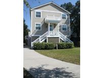 Two story house with light beige siding, white trim, and a front porch at 32 41St Ave, Isle of Palms, SC 29451