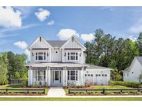 Two-story farmhouse style home with gray siding, a metal roof, and a two-car garage at 2253 Norwood Oaks Dr, Mount Pleasant, SC 29466