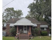 Brick ranch house with a covered porch and landscaping at 2711 Carner Ave, North Charleston, SC 29405