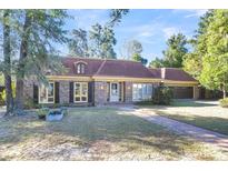 Brick home with brown roof, landscaped lawn, and a paved walkway at 428 Carn St, Walterboro, SC 29488