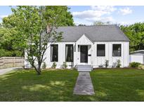 Charming white farmhouse with gray roof, landscaping, and walkway at 3 Penn Ave, Charleston, SC 29407