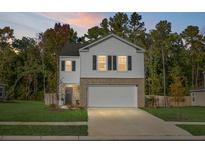 Two story house with white siding, brick bottom, and two car garage at 370 Spruce Ivy St, Moncks Corner, SC 29461