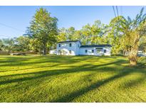 White house with green lawn, large backyard, and mature trees at 112 Cone Ln, Summerville, SC 29483