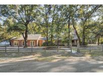 Two-story home with a wraparound porch and mature trees at 4429 Francis Younge Way, Hollywood, SC 29449