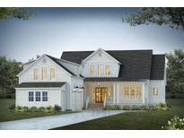 Two-story farmhouse with white siding, dark roof, and a welcoming front porch at 3904 Delinger Dr, Mount Pleasant, SC 29466