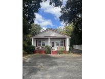 Charming white cottage with red trim, front porch, and ample parking at 507 E 5Th N St, Summerville, SC 29483