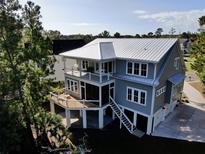 Two-story house with a metal roof, deck, and screened porch at 1999 N Creek Dr, Mount Pleasant, SC 29466