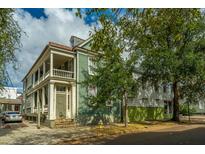 Charming two-story green house with a white porch at 64 Radcliffe St, Charleston, SC 29403