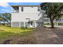 Elevated home with gray siding and a spacious yard at 1008 Mariners Cay Dr, Folly Beach, SC 29439
