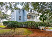 Two-story light blue house with white trim and a wrap-around porch at 5250 Timber Race Crse, Hollywood, SC 29449