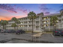Multi-story building with ample parking and palm trees at 93 Mariners Cay Drive, Folly Beach, SC 29439