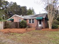 Brick house with green awnings and pine straw at 3034 Maybank Hwy, Johns Island, SC 29455