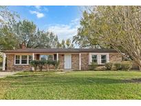 Brick ranch home with a covered porch, mature landscaping, and a large yard at 101 Robin Ct, Summerville, SC 29485
