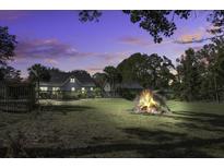 Large backyard with a bonfire at sunset at 443 Lazy Hill Rd, Moncks Corner, SC 29461