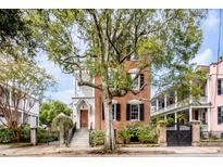 Brick home with three stories, front porch, and large tree at 52 Hasell St, Charleston, SC 29401