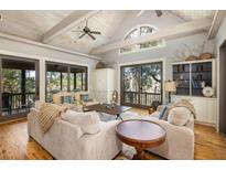 Spacious living room with vaulted ceilings, hardwood floors, and access to a deck at 362 Pelican Flight Dr, Dewees Island, SC 29451