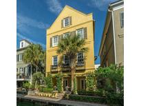 Three-story yellow home with palm trees and lush landscaping at 55 Rialto Rd, Mount Pleasant, SC 29464