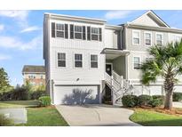 Two-story townhome with white and gray siding, a garage, and a palm tree at 681 Mclernon Trce, Johns Island, SC 29455