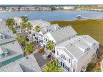 Aerial view of waterfront homes with gray roofs at 108 W 2Nd St, Folly Beach, SC 29439