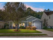 Gray house with a two-car garage and well-manicured lawn at 476 Rockville Rd, Moncks Corner, SC 29461