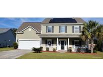 Two-story house with solar panels, porch, and landscaped yard at 1450 Coopers Hawk Dr, Hanahan, SC 29410