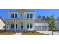 Two-story white farmhouse with front porch and three-car garage at 1172 Reserve Ln, Awendaw, SC 29429