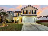 Two-story house with a beige exterior, a white garage door, and a well-manicured lawn at 108 Glenspring Dr, Summerville, SC 29486