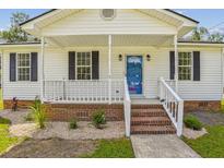 Charming white house with a brick walkway, porch, and landscaping at 11 Behling Ct, Saint George, SC 29477