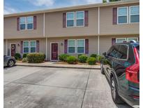 Tan two-story townhome with parking and landscaping at 1064 Lexi Ct, Ladson, SC 29456
