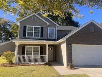Two-story house with gray siding, brick accents, and a white front door at 5164 Torrey Ln, Summerville, SC 29485
