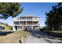 Three-story beach house with multiple decks and a paved driveway at 3611 Yacht Club Rd # B, Edisto Island, SC 29438