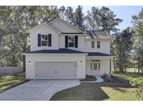 Two-story white house with black shutters, gray roof, and a two-car garage at 5629 Ellington School Rd, Ravenel, SC 29470