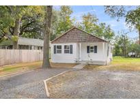 Charming white cottage with wood accents and a gravel driveway at 1979 Macon Ave, North Charleston, SC 29405