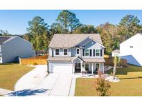 Two-story house with gray siding, white garage door, and landscaped yard at 2009 Elvington Rd, Johns Island, SC 29455