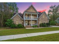 Two-story brick home with a front porch and landscaped yard at 1068 Blockade Runner Pkwy, Summerville, SC 29485