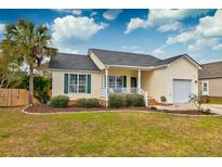 Charming yellow house with a gray roof, green shutters, and a well-manicured lawn at 1074 Wayfarer Ln, Charleston, SC 29412