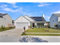 House exterior features a white vinyl sided home with solar panels and a well-manicured lawn at 185 Southport Dr, Summerville, SC 29483