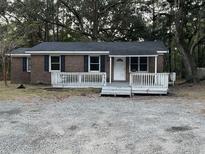 Brick ranch house with front porch and gravel driveway at 4429 Highway 174, Hollywood, SC 29449