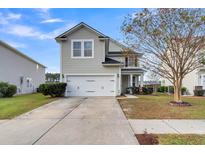 Two-story house with a gray exterior, white garage door, and landscaped yard at 223 Laurel Crest Way, Summerville, SC 29486