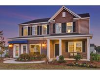 Two-story brick home with a covered porch and landscaped yard at 616 Red Monarch Way, Moncks Corner, SC 29461